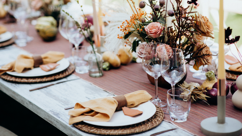 Elegant rustic wedding table setup with floral centerpiece and wine glasses.